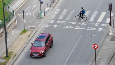 Une voiture sur une route et un vélo sur un passage piéton